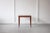 A lovely teak side table or coffee table, featuring lovely grain patterning on its top and long, elegant legs. An...