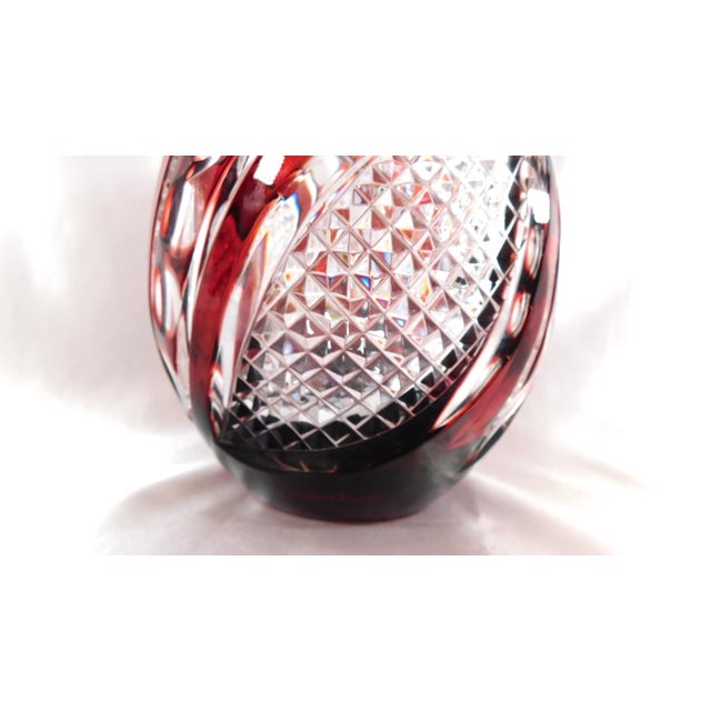 This is a round, teardrop shaped, dark red cut to clear vase. It has no markings on it. The vase is cut in two basic...