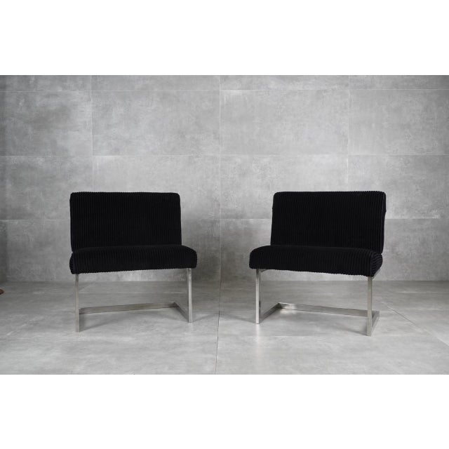 A pair of mid-century cantilever black lounge chairs, designed in the 1970s. The design showcases an ability to blend a...