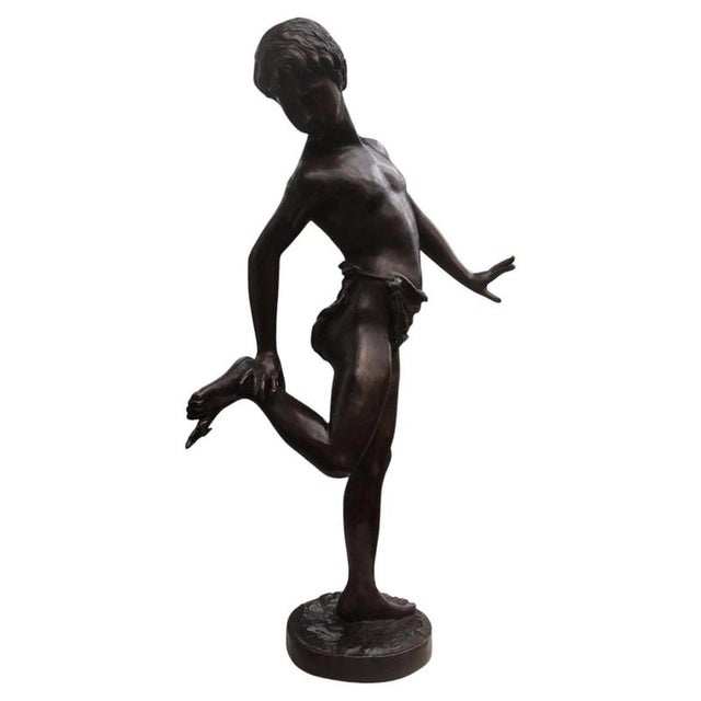 A charming large-scale Italian bronze figure depicting a young boy playfully reacting to a crab hanging from his raised...