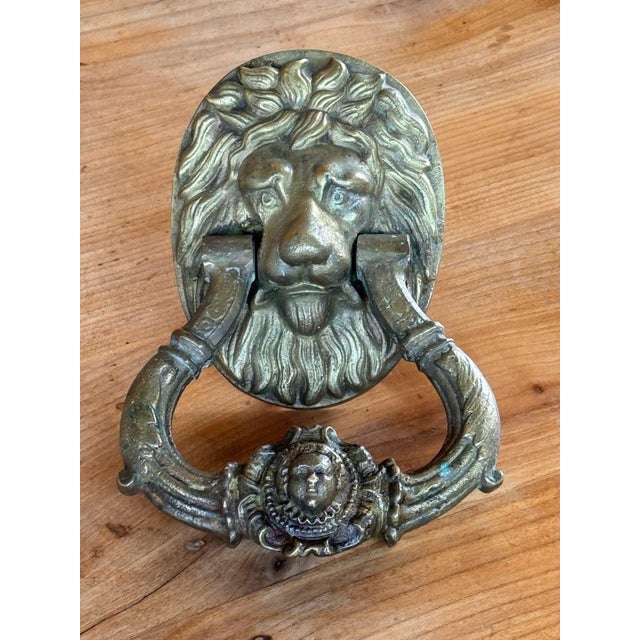 19th century English bronze door knocker cast as a lion mask with a full, flowing mane and beard on an oval backplate. The...