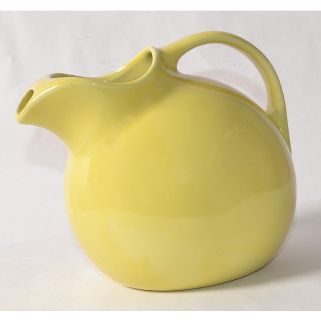This Mid-Century Modern HALL Pottery Tilted Ball Pitcher in Burgundy is perfect for serving beverages. Its 1940s Art Deco...