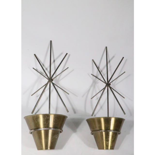 Pr. Mid Century wall mounted planters having steel starburst form brackets, which support brass conical stepped planters,...