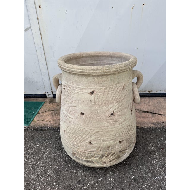 Antique terracotta jar/amphora/vase, handmade with leaf-shaped engravings and triangular and round slits. On the sides it...