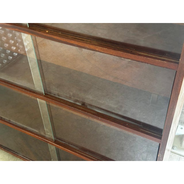 Mid-century Scandinavian bookcase in walnut veneer, equipped with sliding glass doors. Its simple and timeless design...
