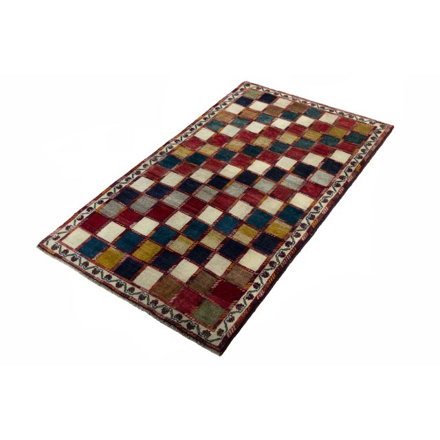 This hand-knotted Gabbeh nomad rug impresses with its characteristic pattern of small color squares in natural tones such...