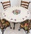 Charming vintage five-piece dining set featuring a round tiled tabletop with an elaborate fruit and grape motif, paired...