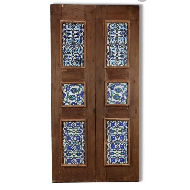 Underglaze-painted lotus and peony tiles set in an old wooden door Comprising ten tiles, eight of the same design,...