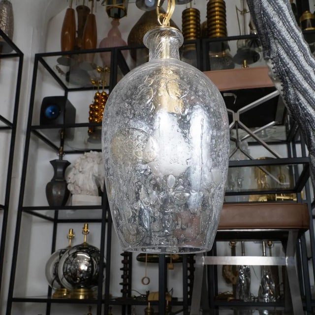 Tulip-shaped glass pendant with large inclusive air bubbles and brass hardware.