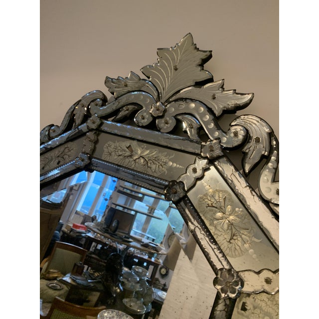 Octagonal Venetian-style mirror with a closed glass panel. The central glass is beveled. The top and bottom pediments are...