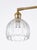An elegant wall light featuring a warm antique brass finish paired with a beautifully shaped clear ribbed glass shade. The...