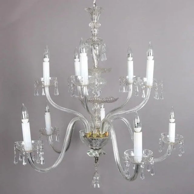 Oversized European crystal chandelier features pressed glass bodice and ten scroll arms terminating in candle lights, cut-...
