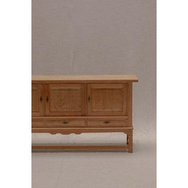 Beautiful solid oak sideboard designed by Henning Kjærnulf, showcasing the warm craftsmanship and understated elegance...