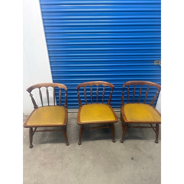 The selected item is a vintage Colonial-style Windsor captain's chair, featuring a low, curved spindle back and an...