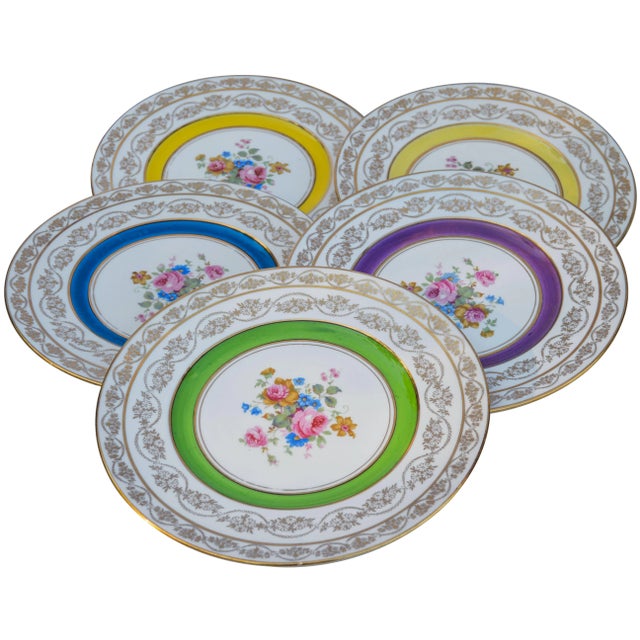 Set of five vintage golden porcelain plates hand-painted with intricate floral pattern, ornate gold rims and colorful...