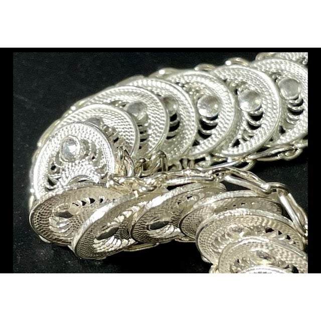 This sterling silver filigree necklace features finely spun articulated discs arranged in a flexible chain design,...