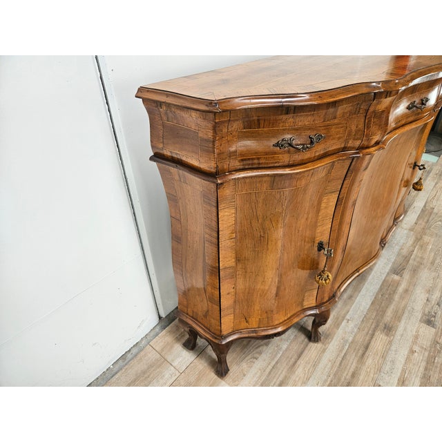 An elegant walnut sideboard crafted in Baroque style, characterized by sinuous lines and excellent construction quality. A...