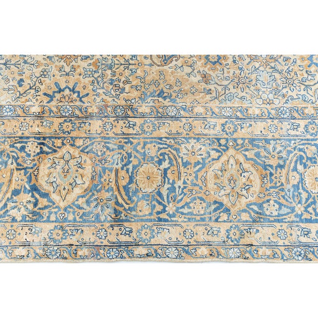 An early 20th century Persian Kerman rugs, the camel field with an allover trellis of palmettes, flowering branches and...