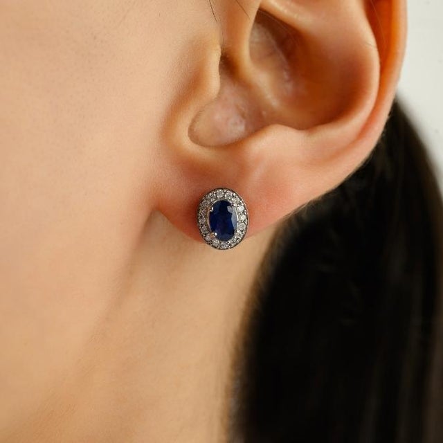 This timeless stud earrings features 2 oval cut natural blue sapphires totaling 1 carat set in 14K white gold. Each...