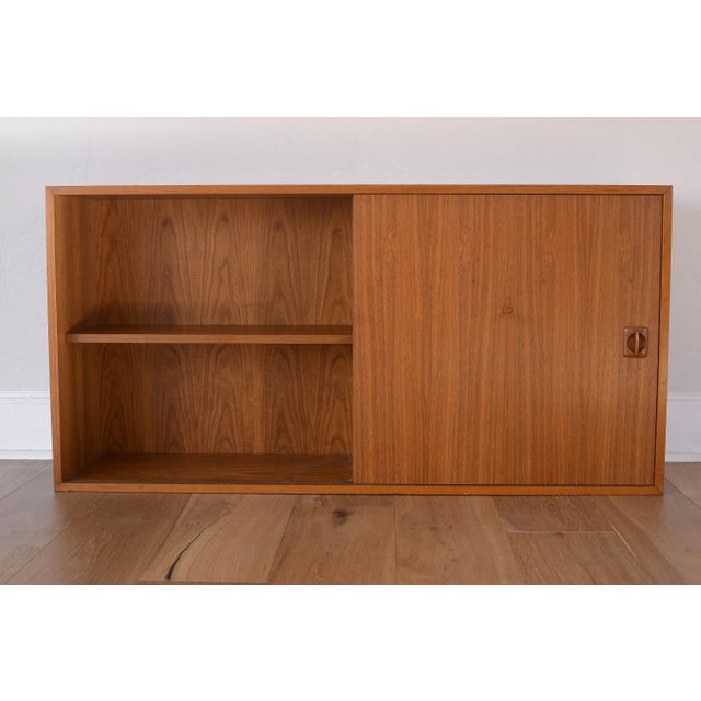 Vintage Danish teak bookcase/cabinet with one sliding door. Originally designed with two doors but this piece comes with...