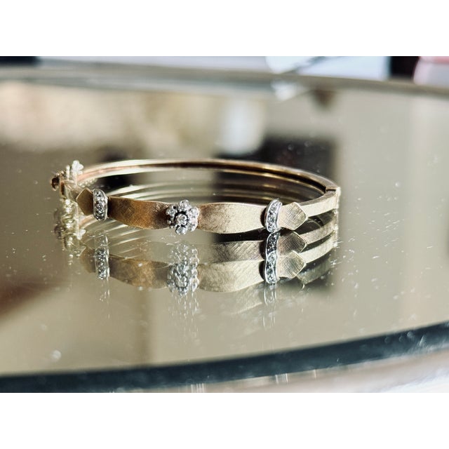 Mid Century 18K yellow gold hinged bangle bracelet featuring a textured Florentine finish with a cross hatched surface...
