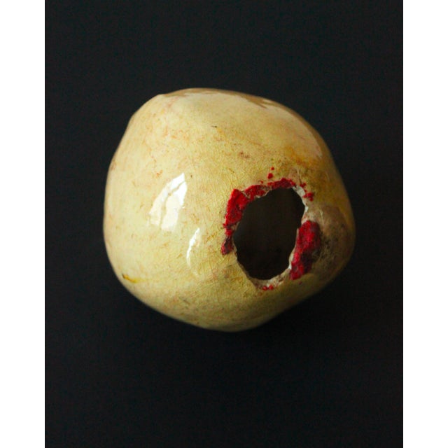 A charming glazed ceramic piggy bank in light straw-yellow tones, shaped like a pear. A piece of French folk art from the...