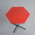 Red hexagonal tabletop, circa 1970. The tabletop, with its gently rounded corners, rests on a central metal column topped...