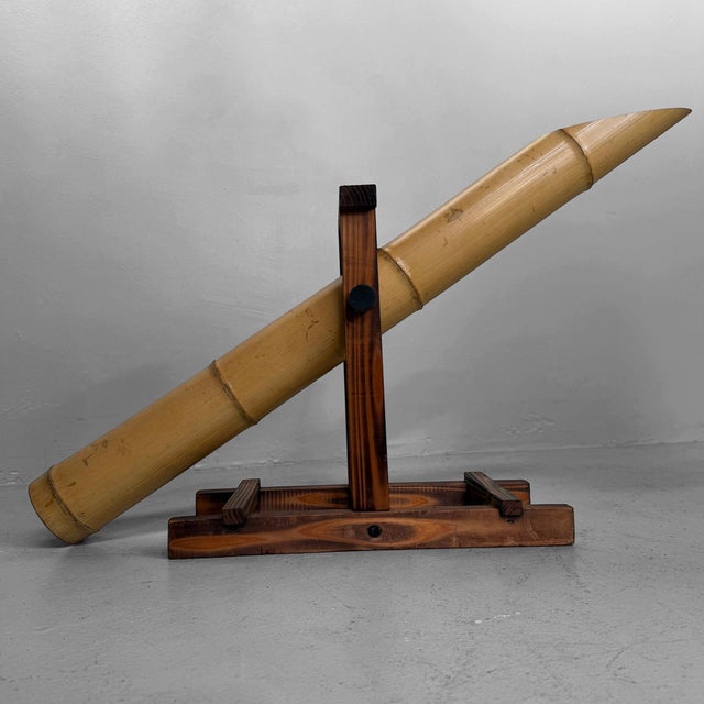 A refined Japanese garden object in bamboo and wood, with the traditional tipping mechanism of a shishi-odoshi....