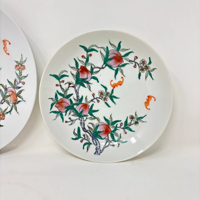 A vintage 7.5 inch porcelain bowl hand-decorated with peach trees and fruit, and flying bats. Good condition.