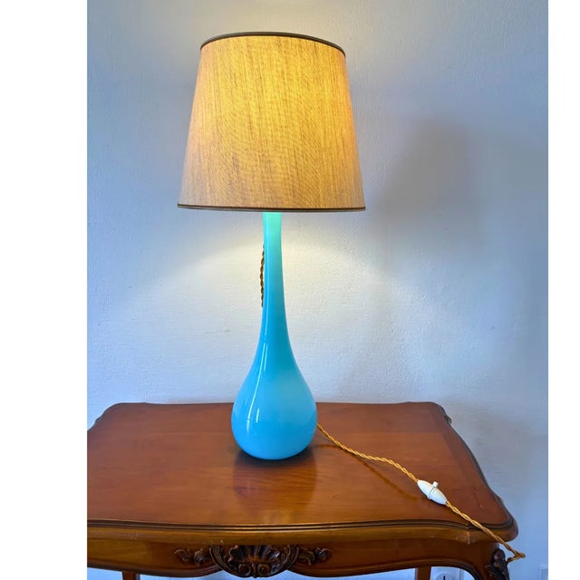 Elegant Mid-Century Murano glass table lamp, crafted in Italy in the 1960s. The lamp features a striking hand-blown Murano...