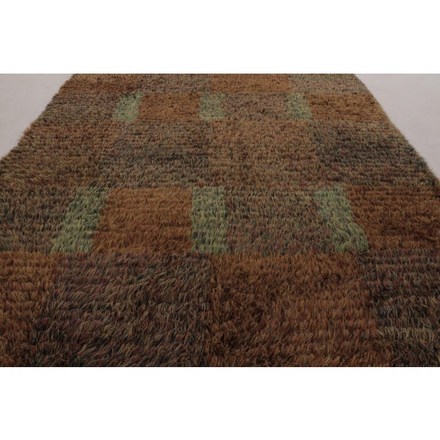 Hand-knotted in high-pile wool in Sweden circa 1960-1970, this 10x13 vintage Swedish Rya rug is a monumental new addition...
