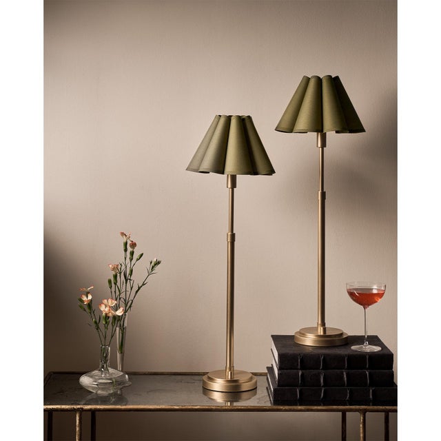 The Polly Buffet Table Lamp showcases sophistication with its single scalloped shade, casting a warm and inviting glow...