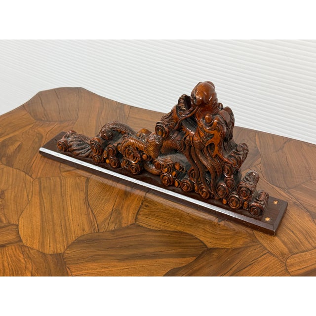 Design Plus Gallery presents a Dragon Sculpture Carved from Wood. The Dragon is mounted on a display piece to stand...