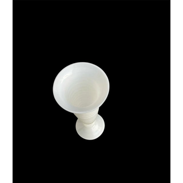 Vintage from Italy. Hand-blown art glass vase with a ribbed pattern. The vase is made of clear glass over a white cased...