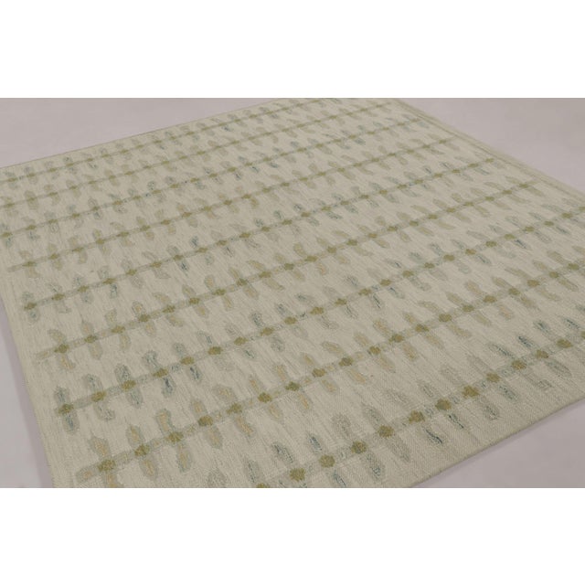Handwoven in an intricate blend of wool and undyed, natural yarns, this 9x8 flatweave is a premier selection from our...