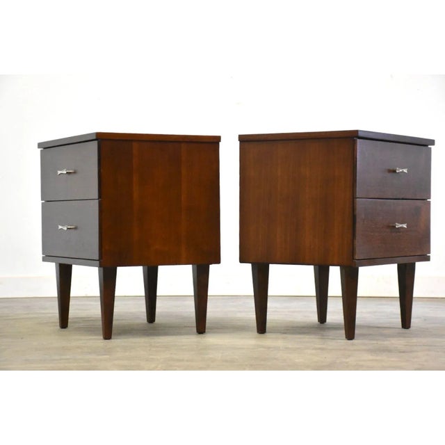A pair of mid century modern walnut two drawer nightstands with chrome pulls made by Harmony House. Professionally...