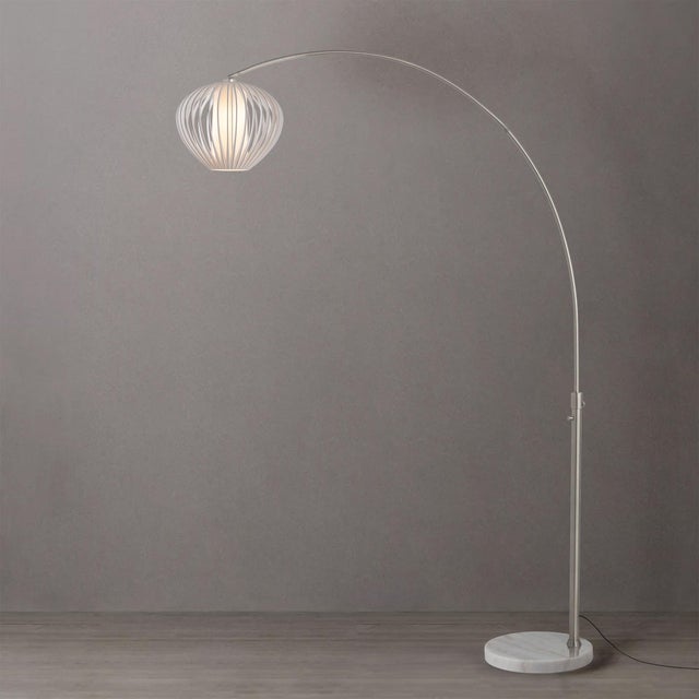 The Float Arc Lamp is a sophisticated lighting fixture with a satin nickel steel body and a sphere white satin steel...