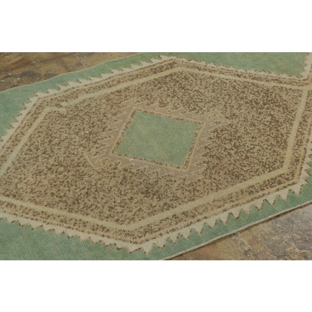 Hand-knotted in wool circa 1950-1959, this 3x12 vintage Turkish runner originating from Turkey is a compelling addition to...