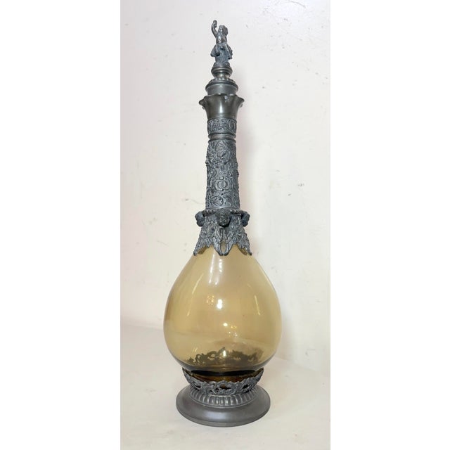 This antique hand blown pewter mounted glass figural German decanter is a unique and collectible piece of barware from the...
