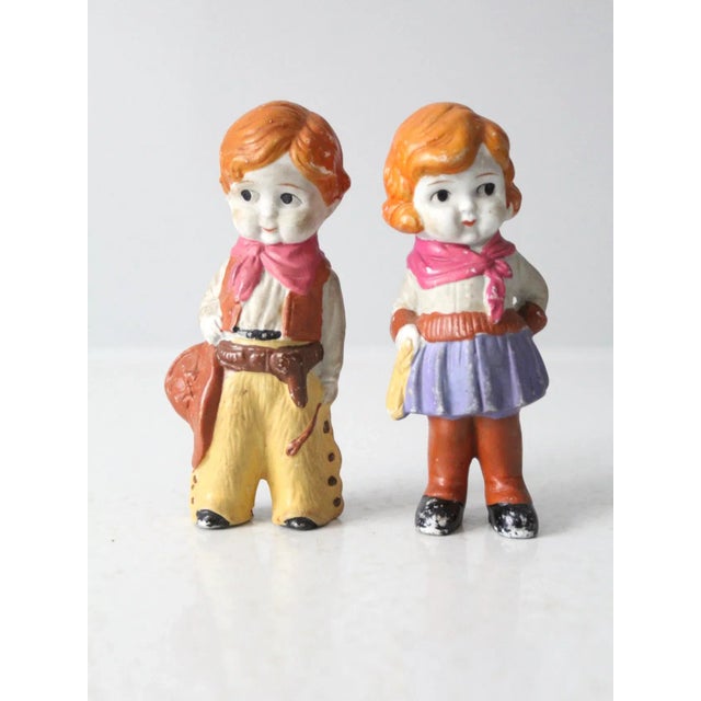 This is an adorable pair of bisque ceramic cowgirl & cowboy figurines circa 1930s. The sweet faced boy and girl dolls have...