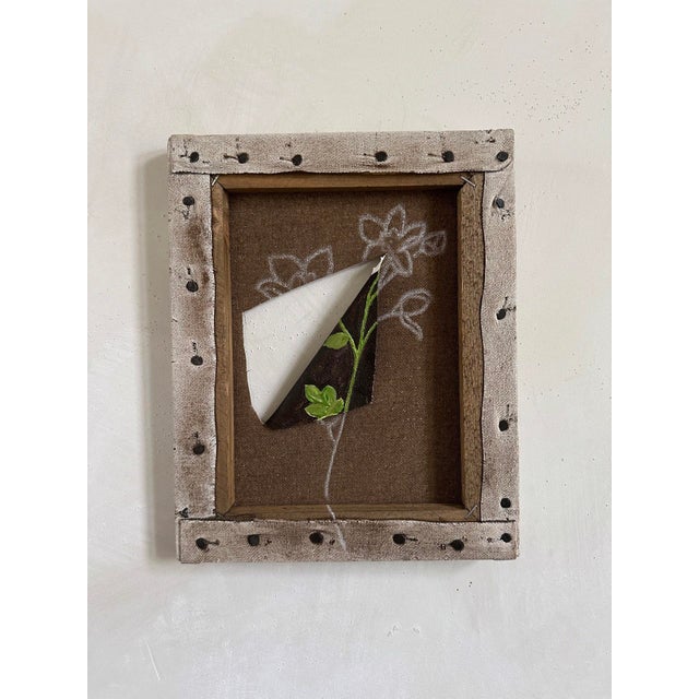 The artwork presents a dynamic interplay between painted elements and a three-dimensional paper cutout, creating a sense...