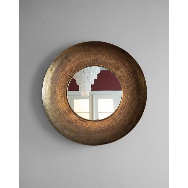 A 1970s mirror with a hand-hammered copper frame is an example of metal craftsmanship. with its thick frame and mirror in...