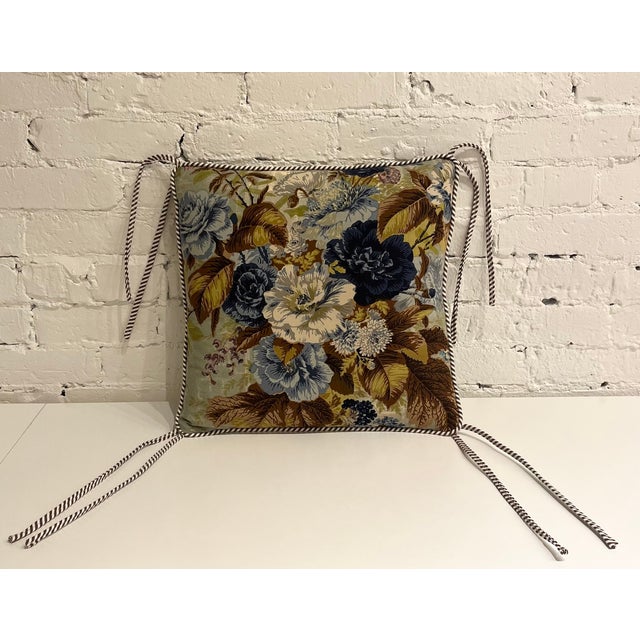 Walnut-stained pine wood stool with a curved, hand-woven cord seat and turned leg detailing. Includes a loose floral seat...