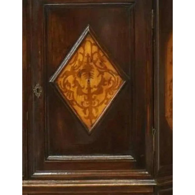 An Italian walnut corner cabinet, molded cornice, over triangular case, upper and lower cupboard doors with contrasting...