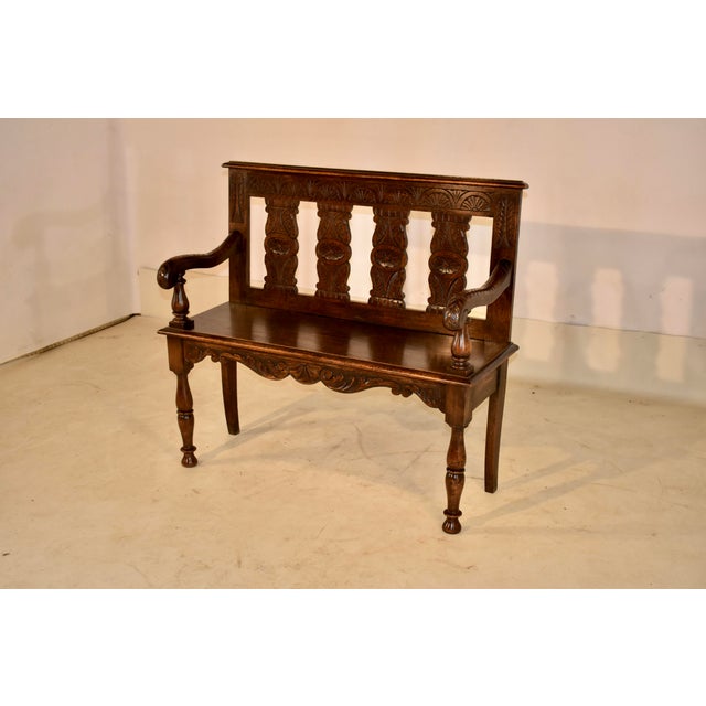 19th century French oak settee with hand carving. The back is carved and has a molded edge over three vase shaped carved...