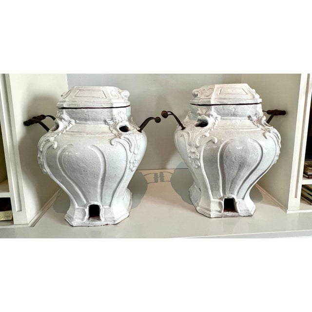 A unique pair of Glazed Terracotta planters or Urns with metal and wood handles and removable lid. The pair have a...