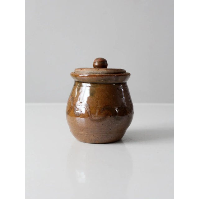 This is a vintage studio pottery jar date 2002. Signed by the artist, Whitney Rose, the hand-crafted jar features a...