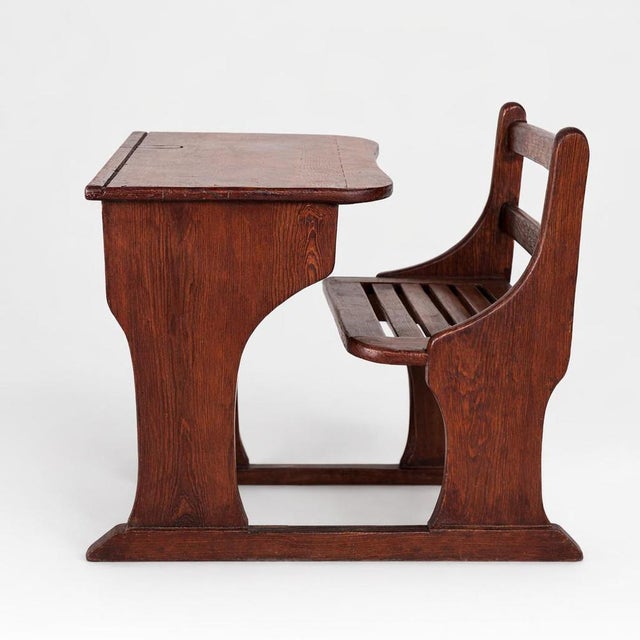 A charming antique pine school desk with integrated bench seat, full of character and traditional craftsmanship. This...