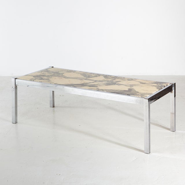 Angular shaped coffee table with chrome legs and marble top from the 1970s. with some surface scratches and wear on the...