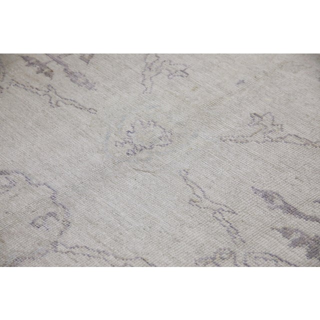 This modern Turkish Oushak rug is a stunning piece of art that has been handwoven using traditional techniques by skilled...